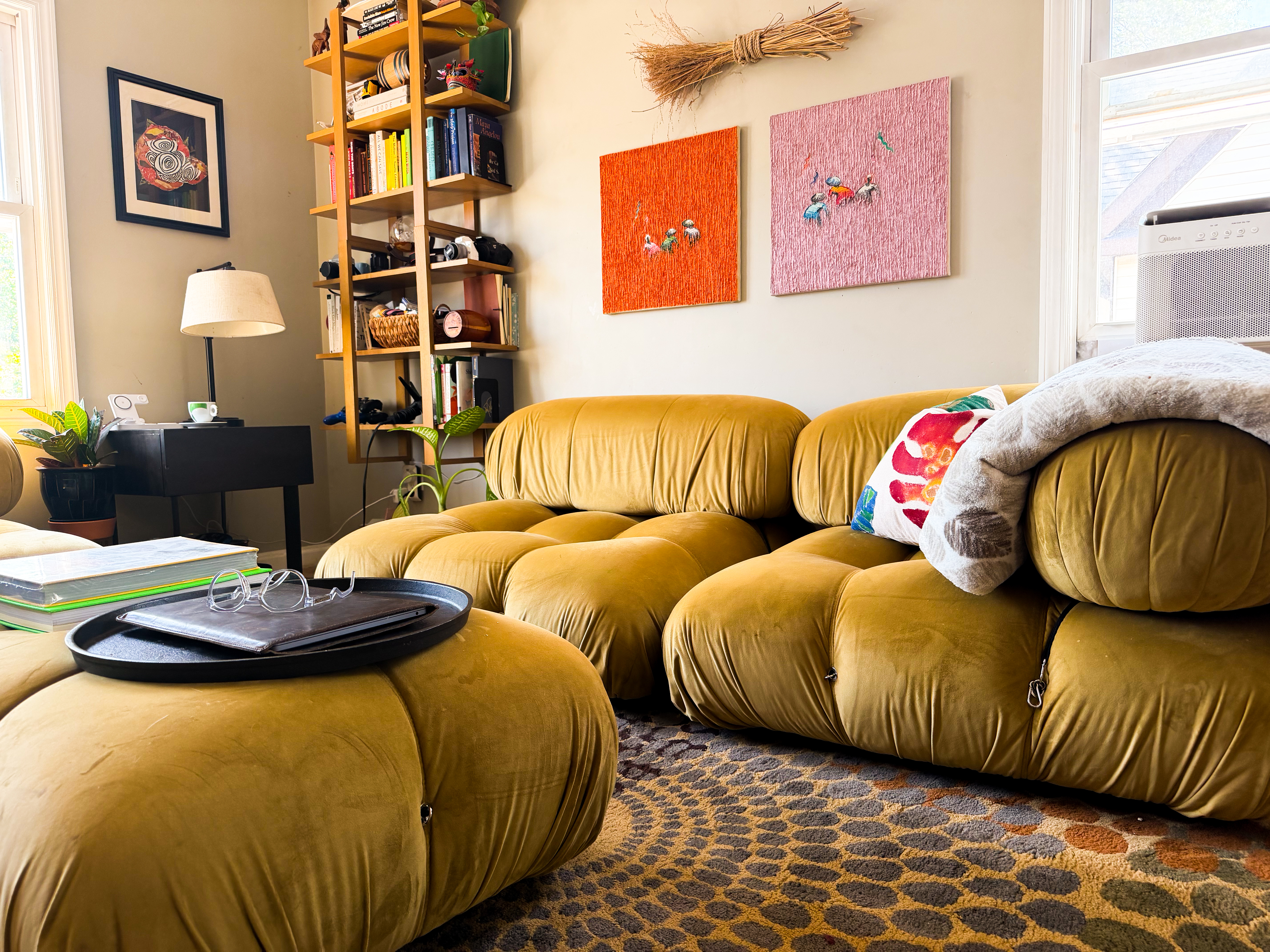 Sourced living room with curated art wall and mustard velvet modular sofa